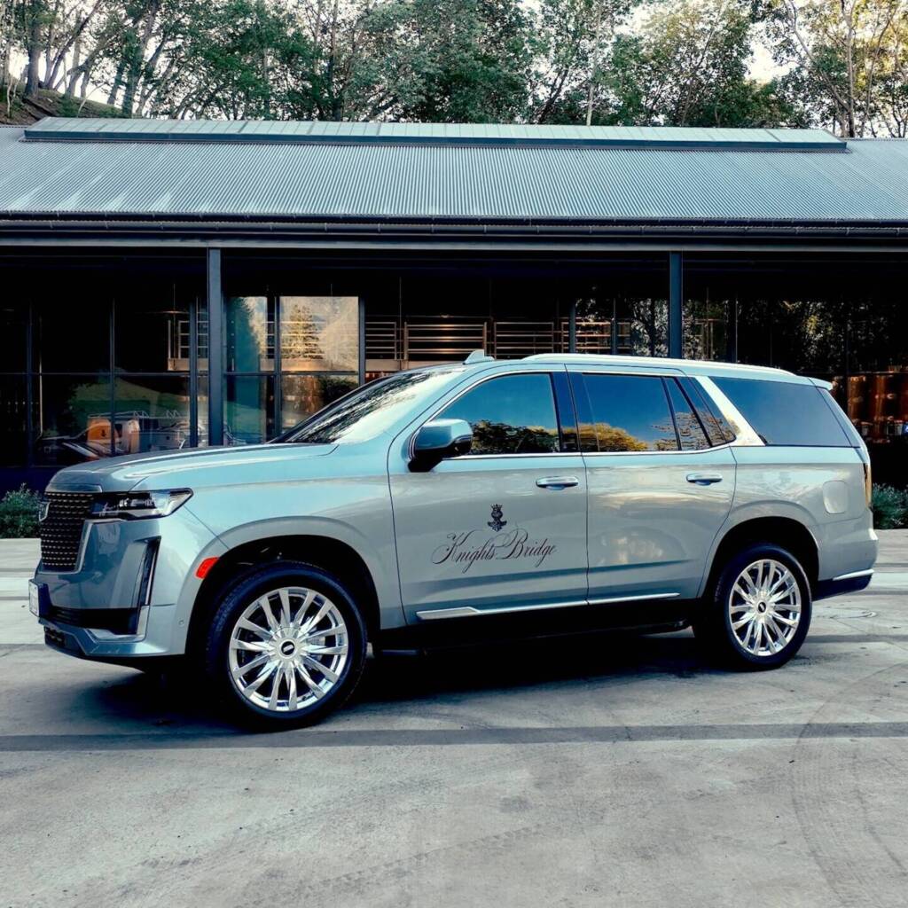 Cadillac SUV with Knights Bridge logo in front of winery.
