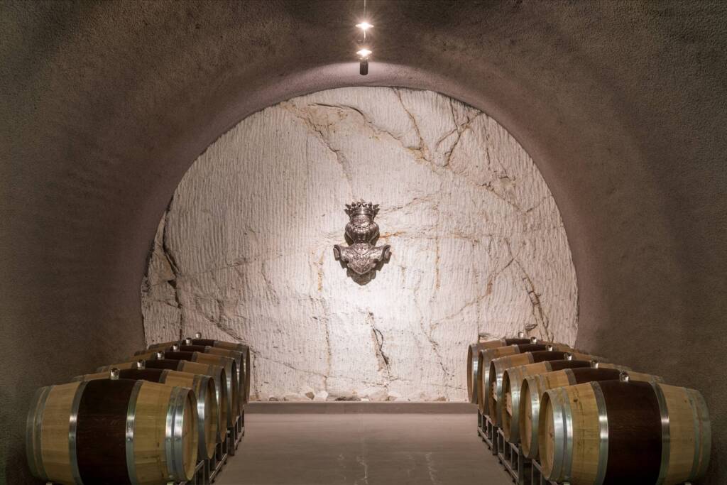 Dramatically lit row of barrels with knight logo on wall in back