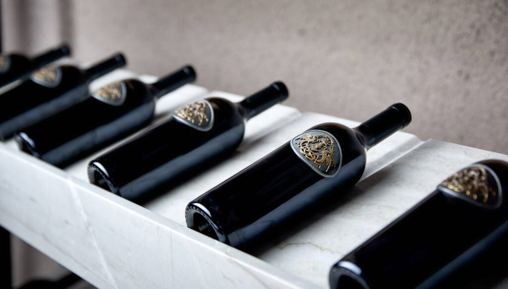 Draco bottles on white marble shelf.